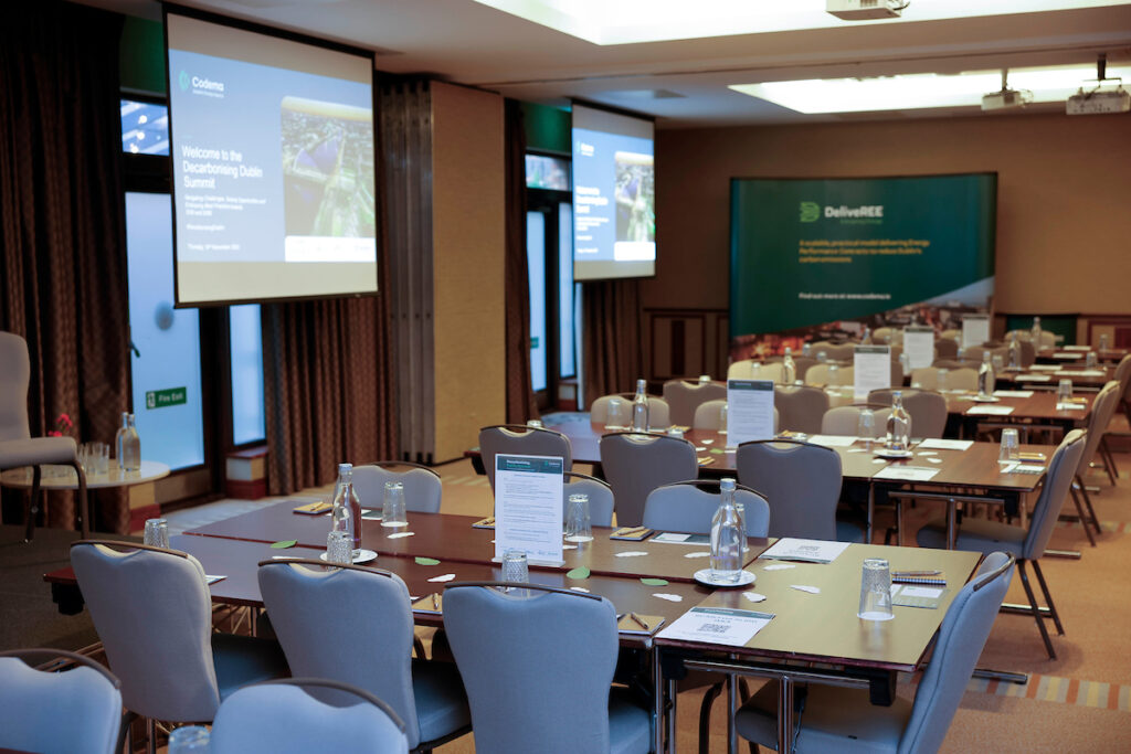 Photo of a stage and empty tables in a conference room, at the Decarbonising Dublin Summit 2024