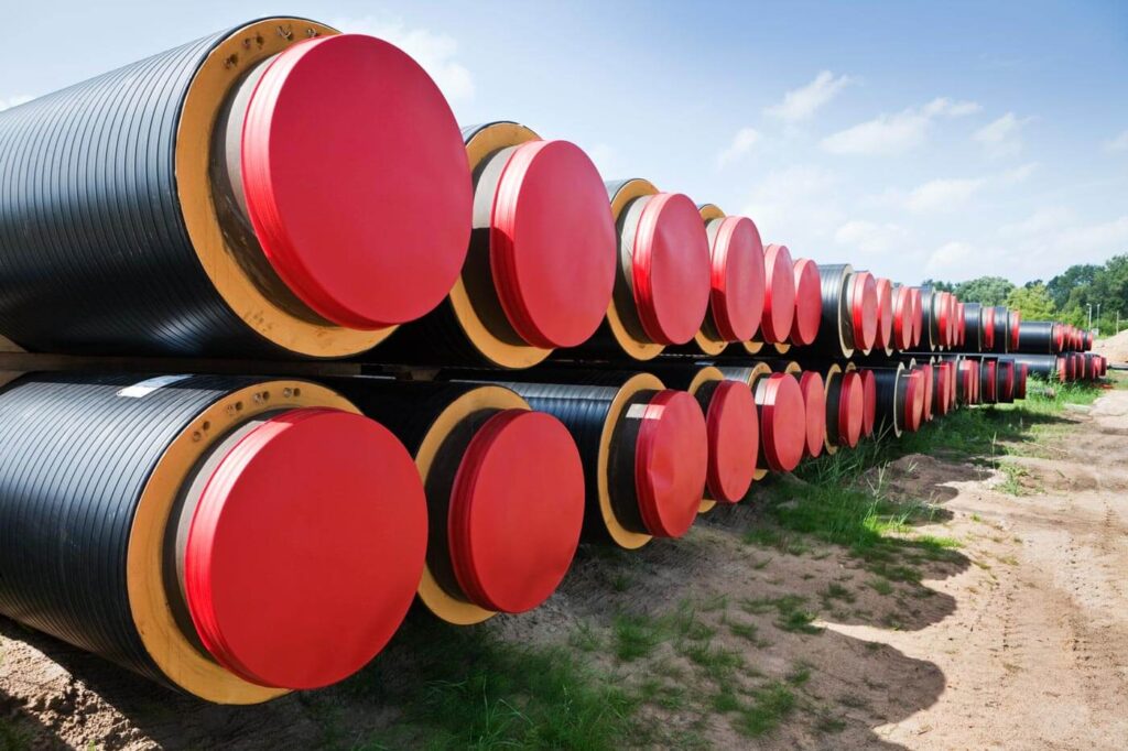 Photo of district heating pipes stacked on the ground - illustrative of pipes used in district heating systems