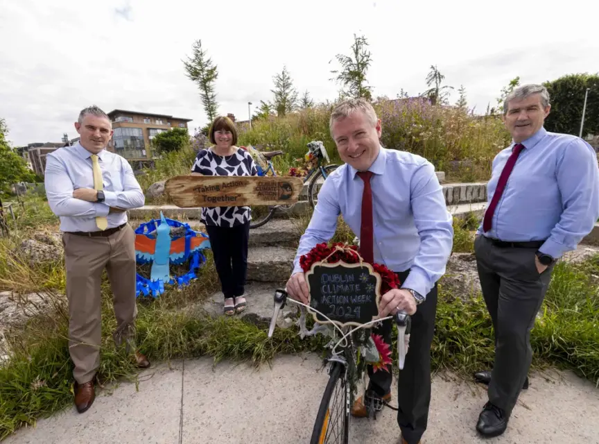 Photo of launch of Dublin Climate Action Week - three men and one woman pose with a bicycle and sign