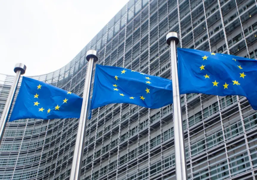 Three EU flags in front of a large building