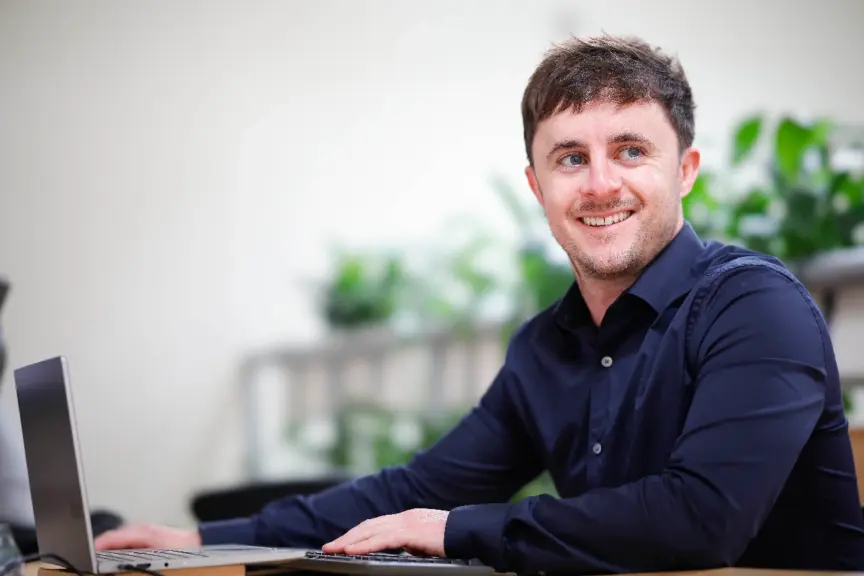 A Codema staff member sits at a desk smiling