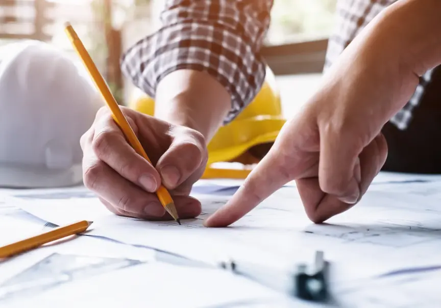 Image of someone writing with a pencil and a finger pointing at a page