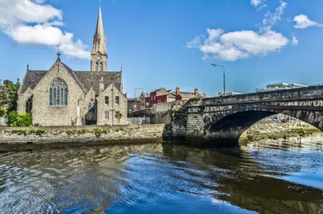 Image of St. Patrick's Church in Ringsend with the river in the foreground and a bridge to the right.