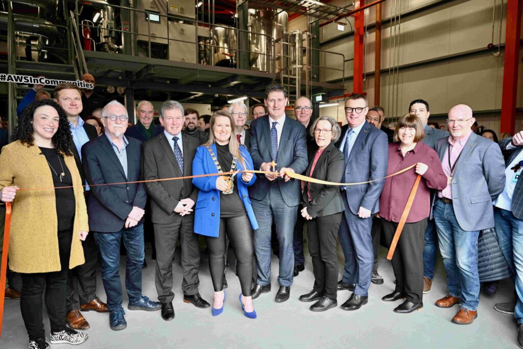 Image of a largue ground of people including Minister for Environment Eamon Ryan cutting a ribbon at the opening of the Tallaght District Heating Scheme