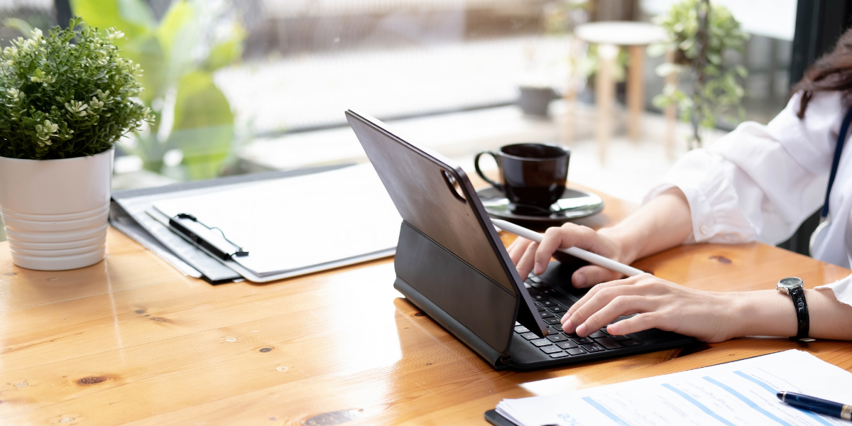 Image of office worker typing on their laptop.