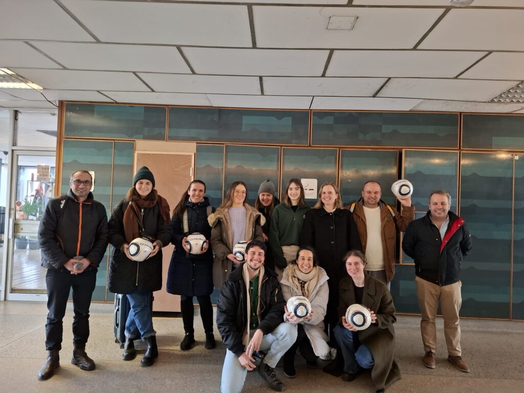 Group of people holding footballs and smiling