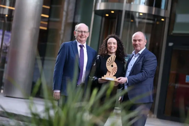 Picture of Donna Gartland being presented the Positive Impacts Award by Kevin O'Sullivan and Errol Close.